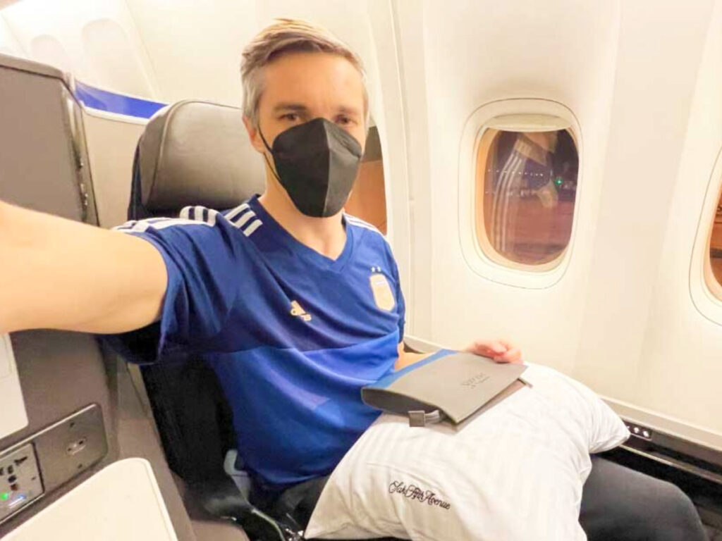 Nate Hake wearing a face mask and posing for a photo inside the plane